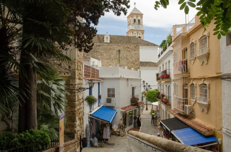 Marbella old town street with church tower, starting point for Marbella to Tangier day trips